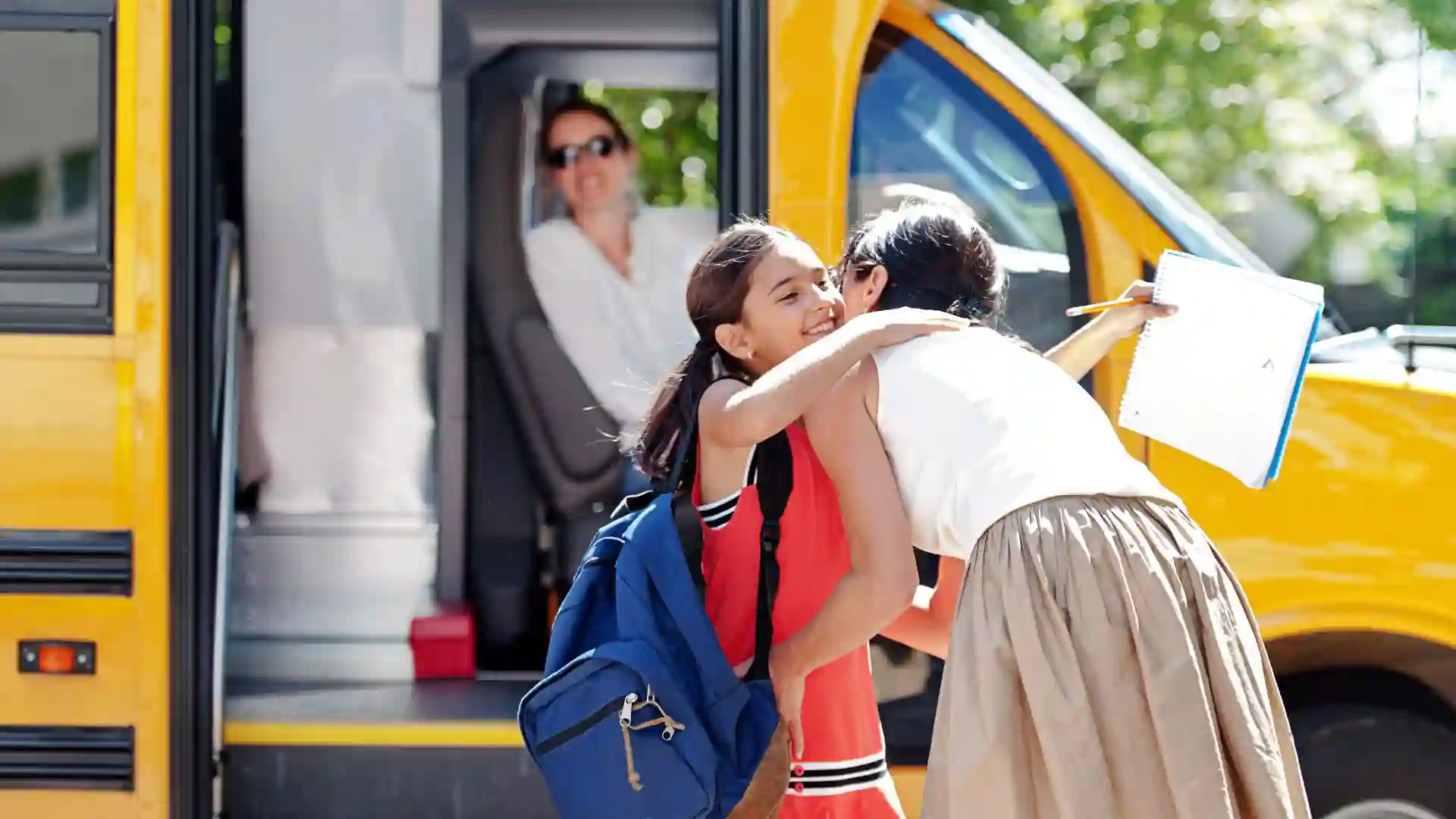 daughter hugging mom goodbye to get on school bus